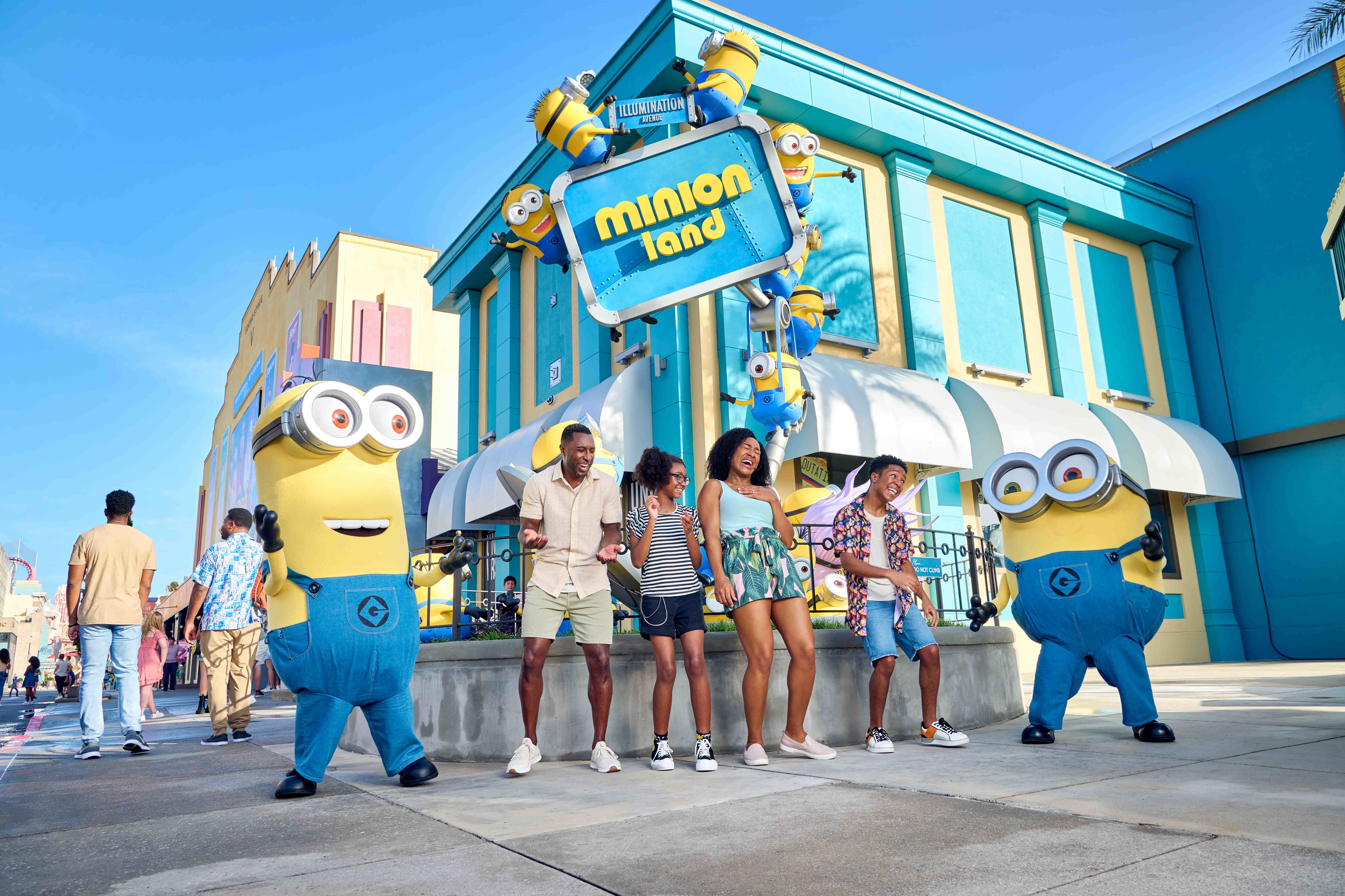 family in front of minion land marquee
